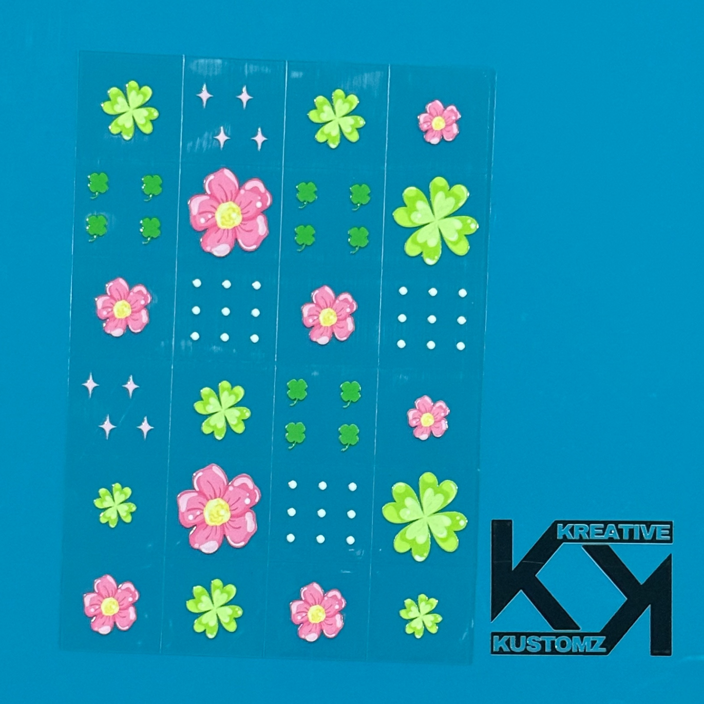 An A5 sheet of 24 floral and clover UV DTF adhesive decals on a blue background.