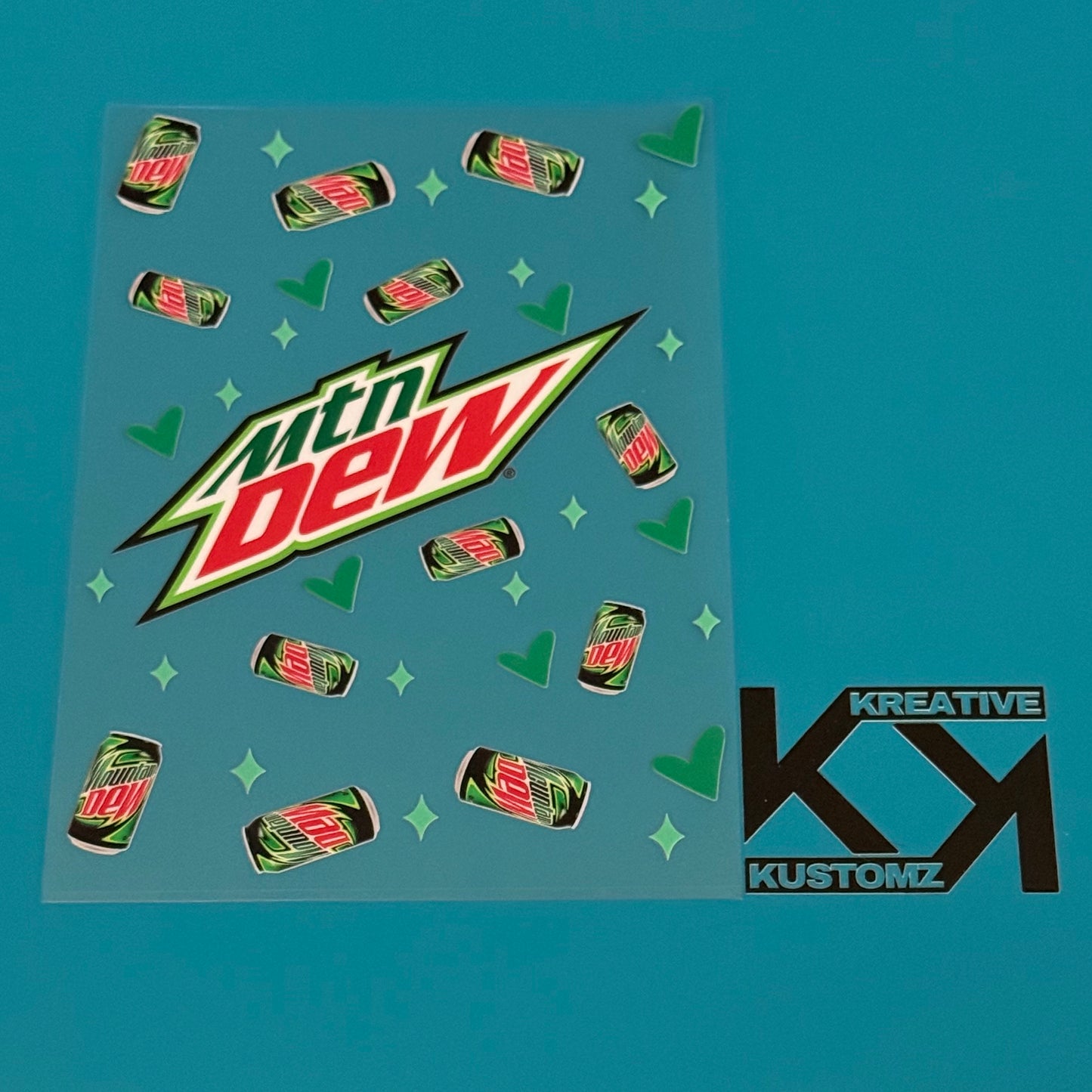 A Mountain Dew themed UV DTF decal sheet featuring soda cans, hearts, and stars on a clear film.
