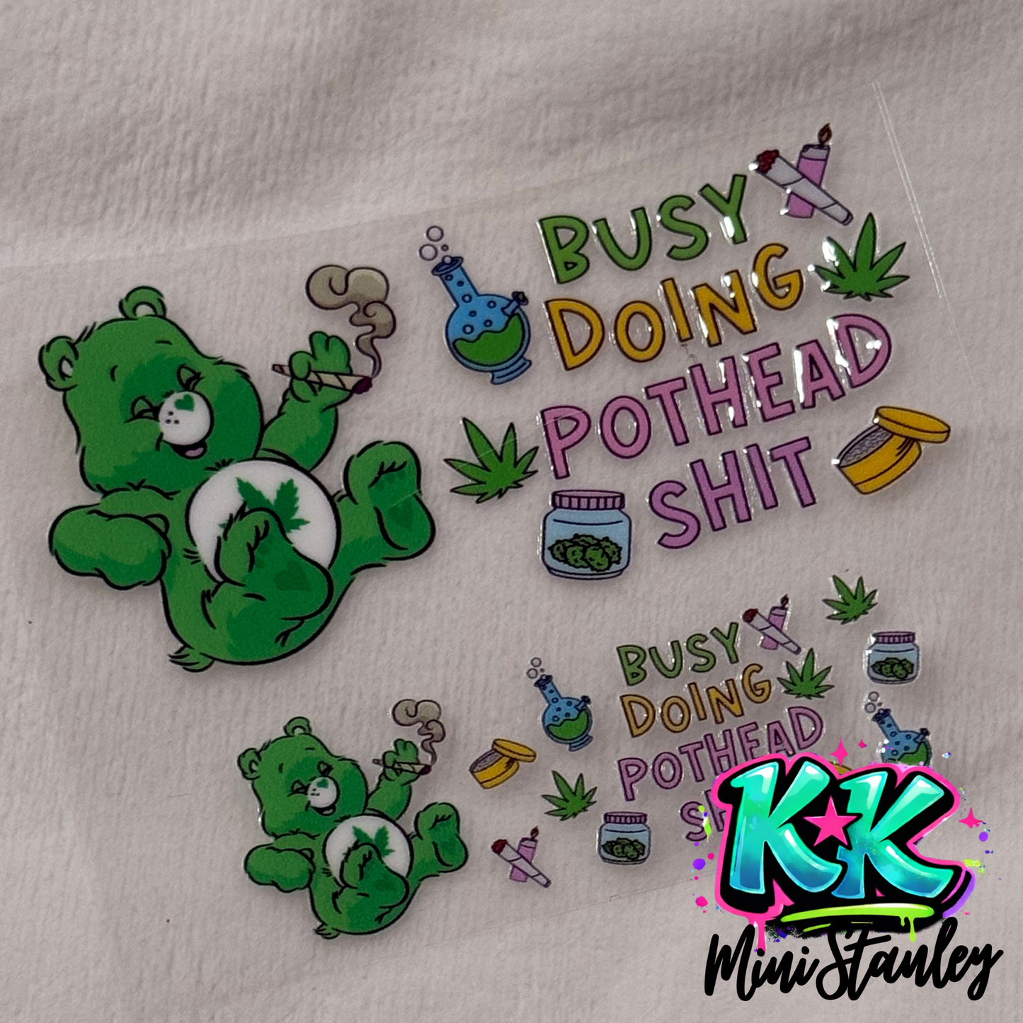 Two UV DTF adhesive transfers featuring a green bear smoking and cannabis-themed graphics.