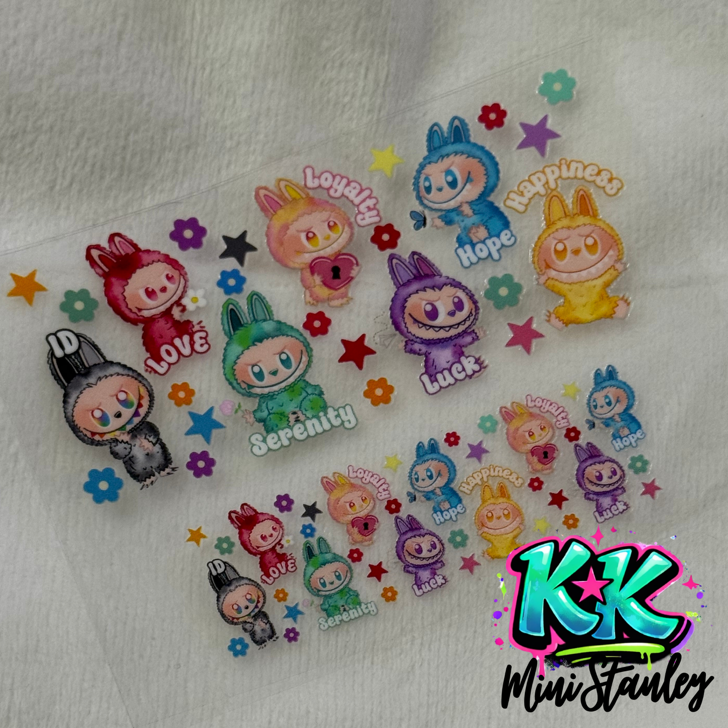 Two sheets of UV DTF adhesive transfers featuring colorful cartoon characters and text labels.