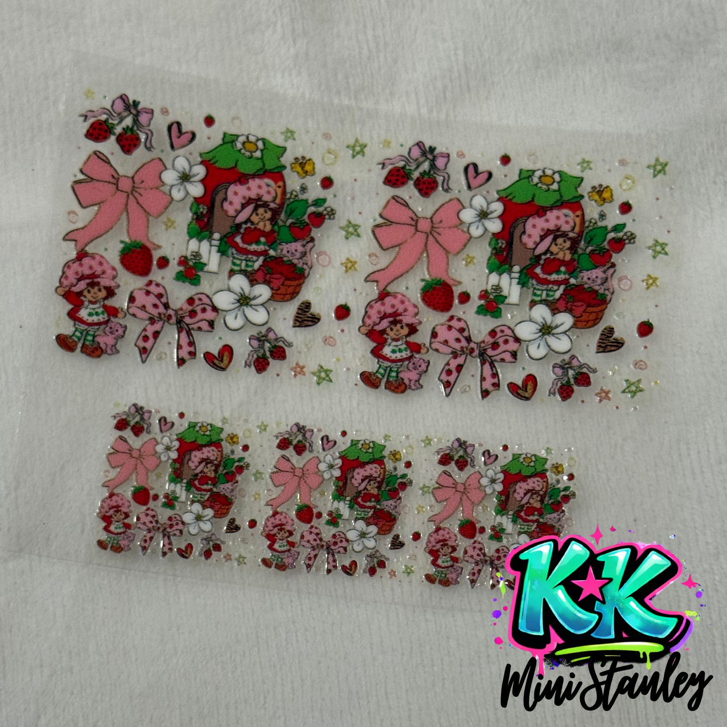 Two sheets of Strawberry Shortcake themed UV DTF adhesive decals for mini cup keychains.