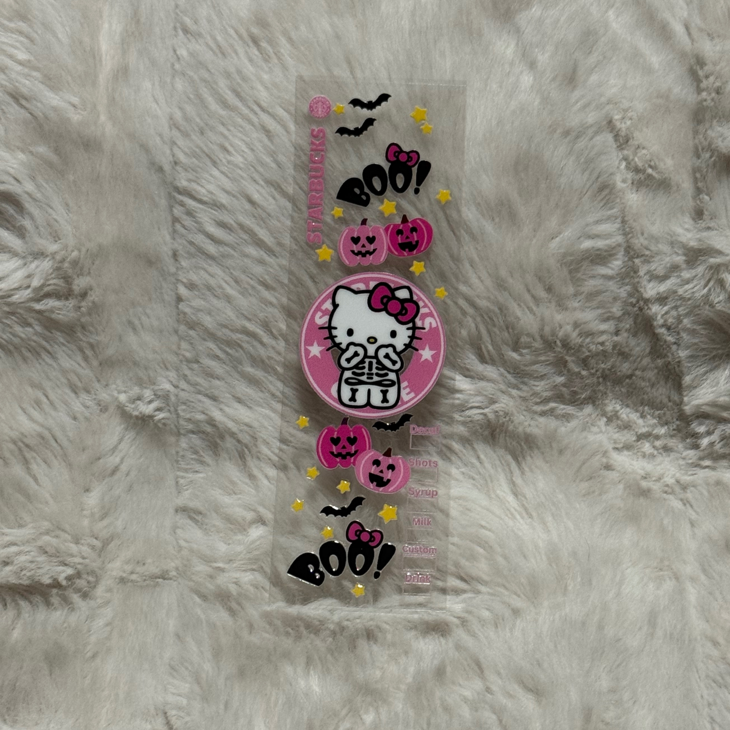 A Hello Kitty Halloween themed UV DTF adhesive pen wrap with pumpkins, bats, and stars.