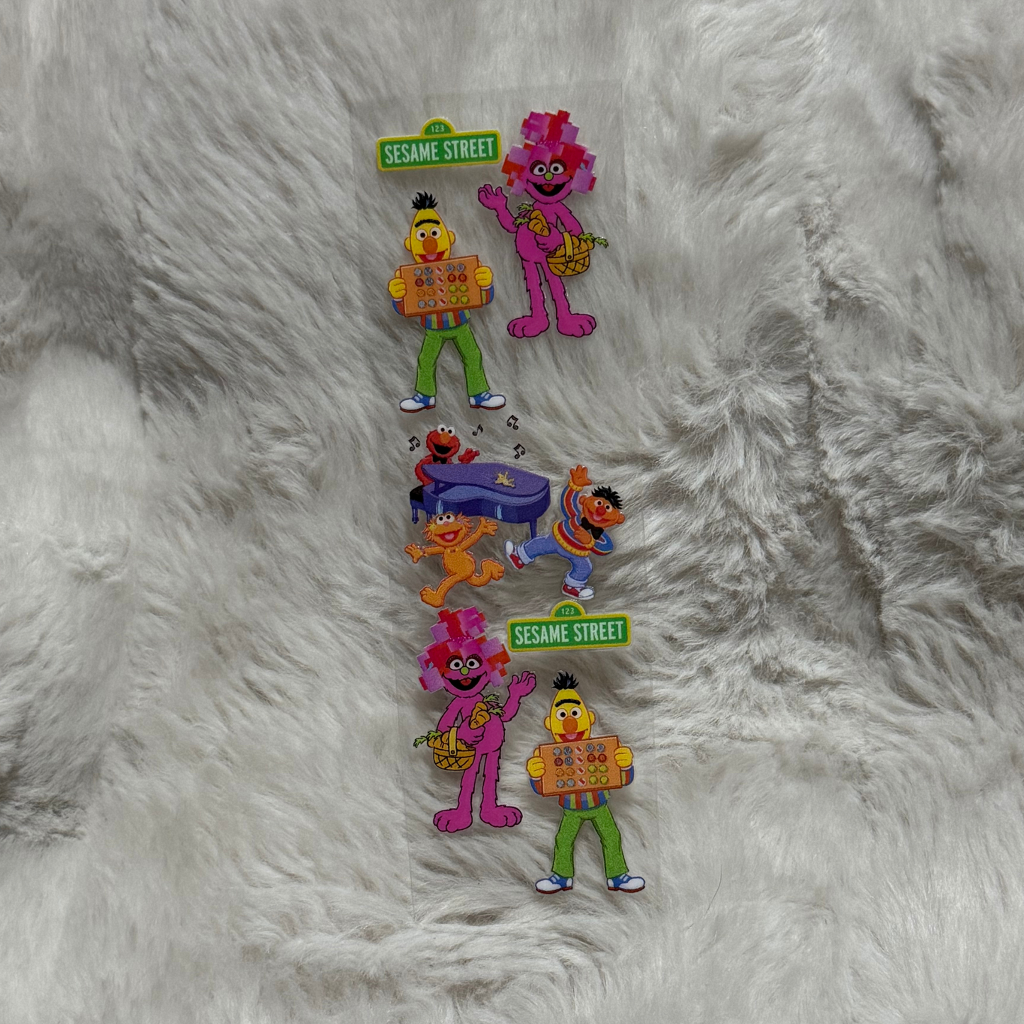 A vertical sheet of Sesame Street stickers featuring Bert, Abby Cadabby, and Elmo.