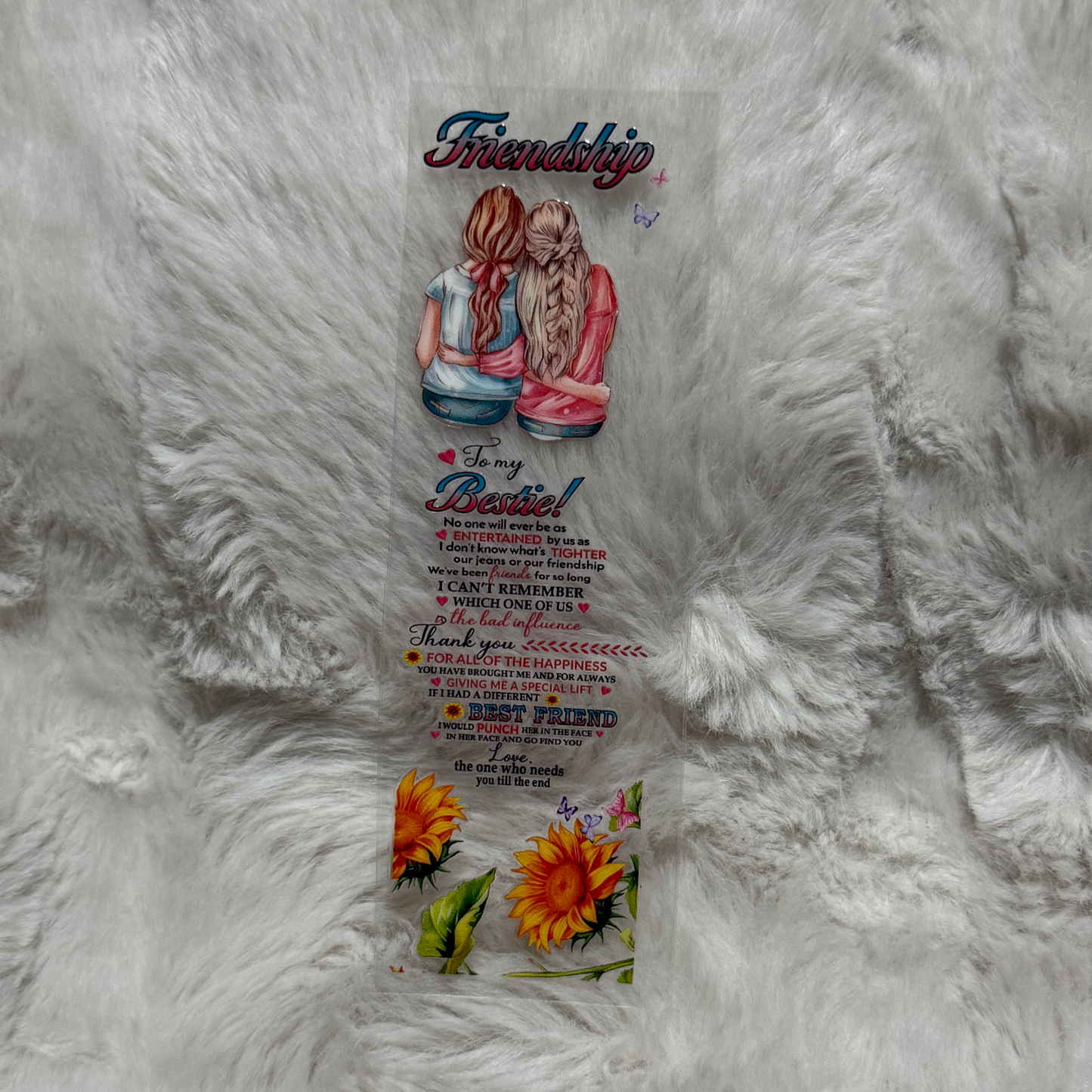 A clear adhesive pen wrap featuring an illustration of two friends and sunflower accents.