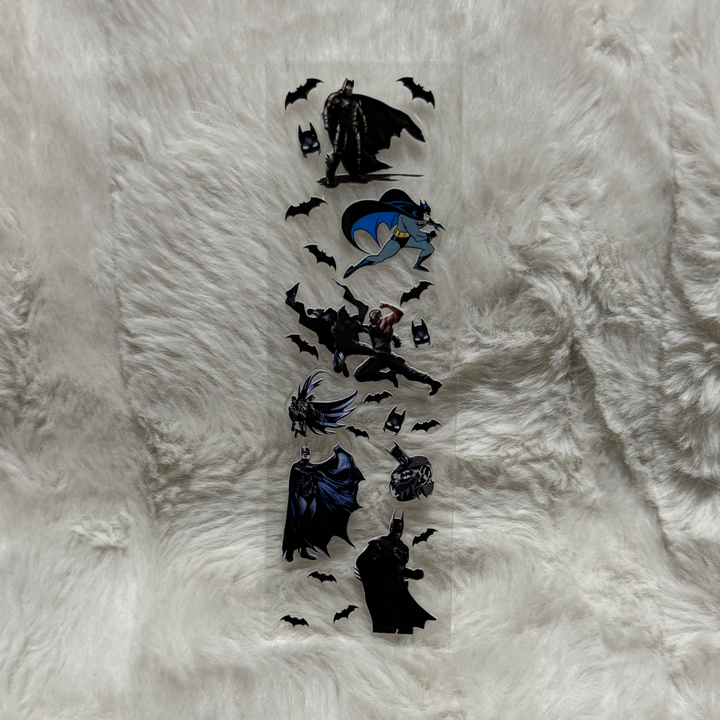 A clear UV DTF adhesive pen wrap featuring various Batman character illustrations and bat symbols.