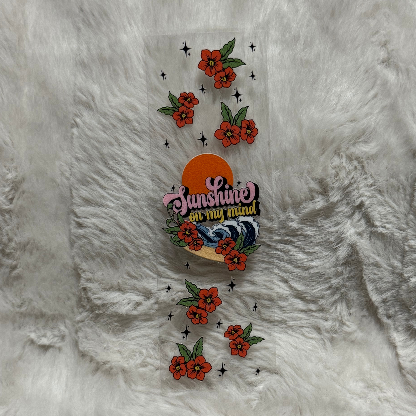 A clear adhesive pen wrap featuring red flowers, sparkling stars, and a sunshine graphic.