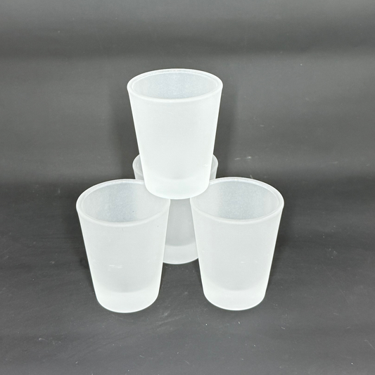 Three frosted matte glass shot glasses are arranged in a pyramid formation against a dark background.