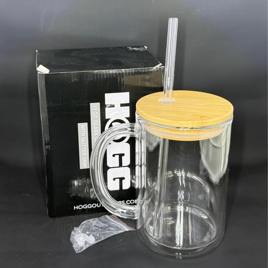 A 15-ounce double-wall glass coffee mug with a bamboo lid, clear straw, and a small plug.