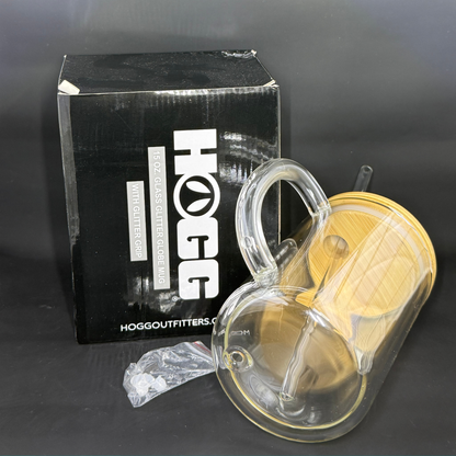 A 15oz double-wall glass mug with a wooden lid, straw, and plug, shown next to its HOGG box.