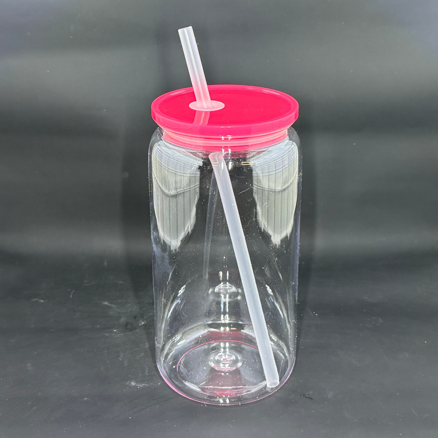 A clear 16oz acrylic beer can tumbler with a dark pink lid and a matching straw.