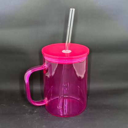 A translucent pink glass coffee mug with a matching lid, handle, and clear straw.
