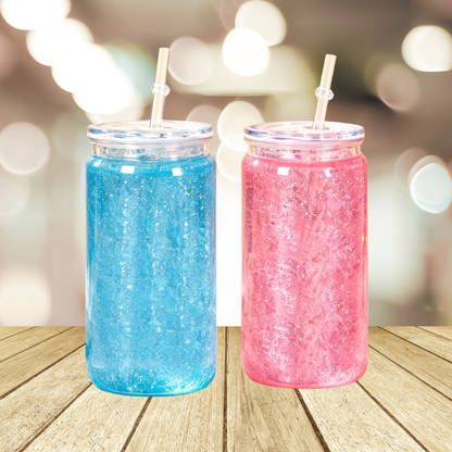 Two 16oz acrylic snow globe tumblers with lids and straws, one filled with blue and one with pink glitter.