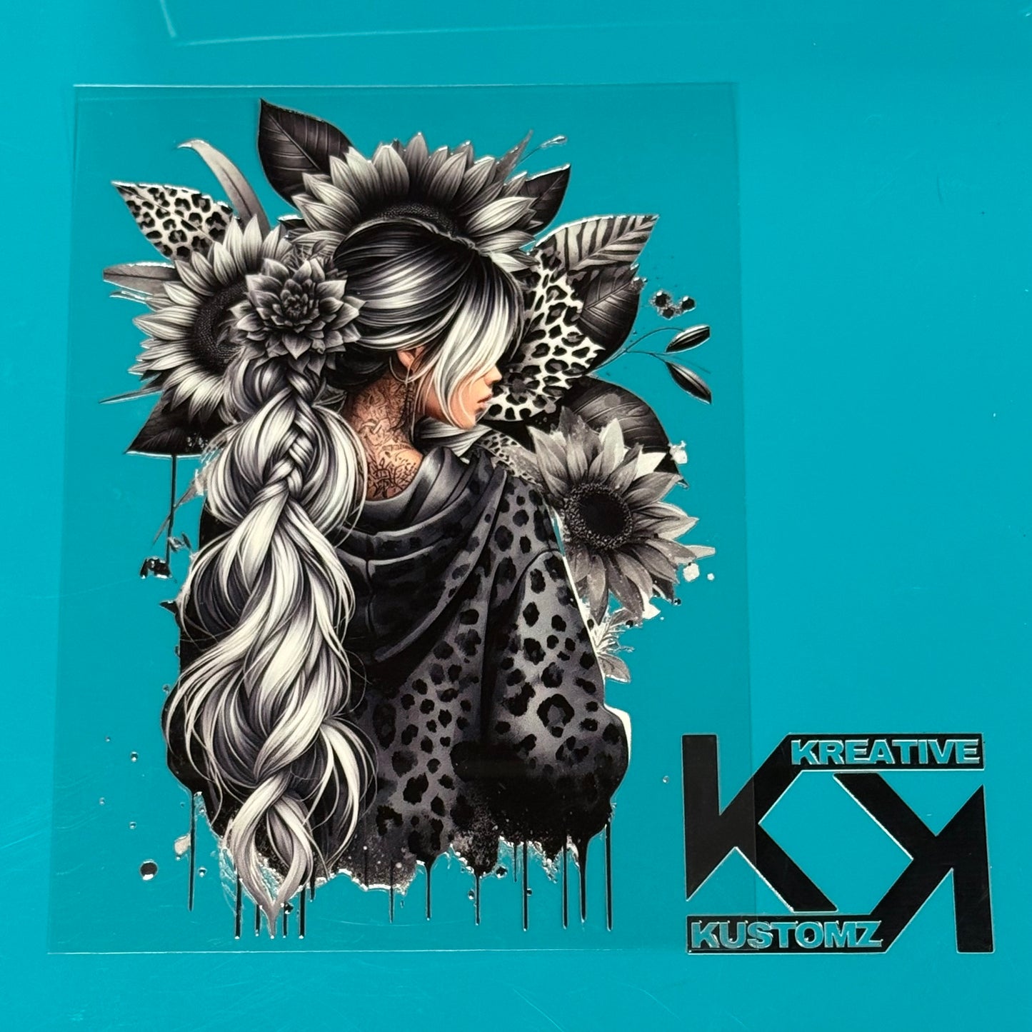 A grayscale UV-DTF decal featuring a woman with a long braid surrounded by sunflowers and leopard.