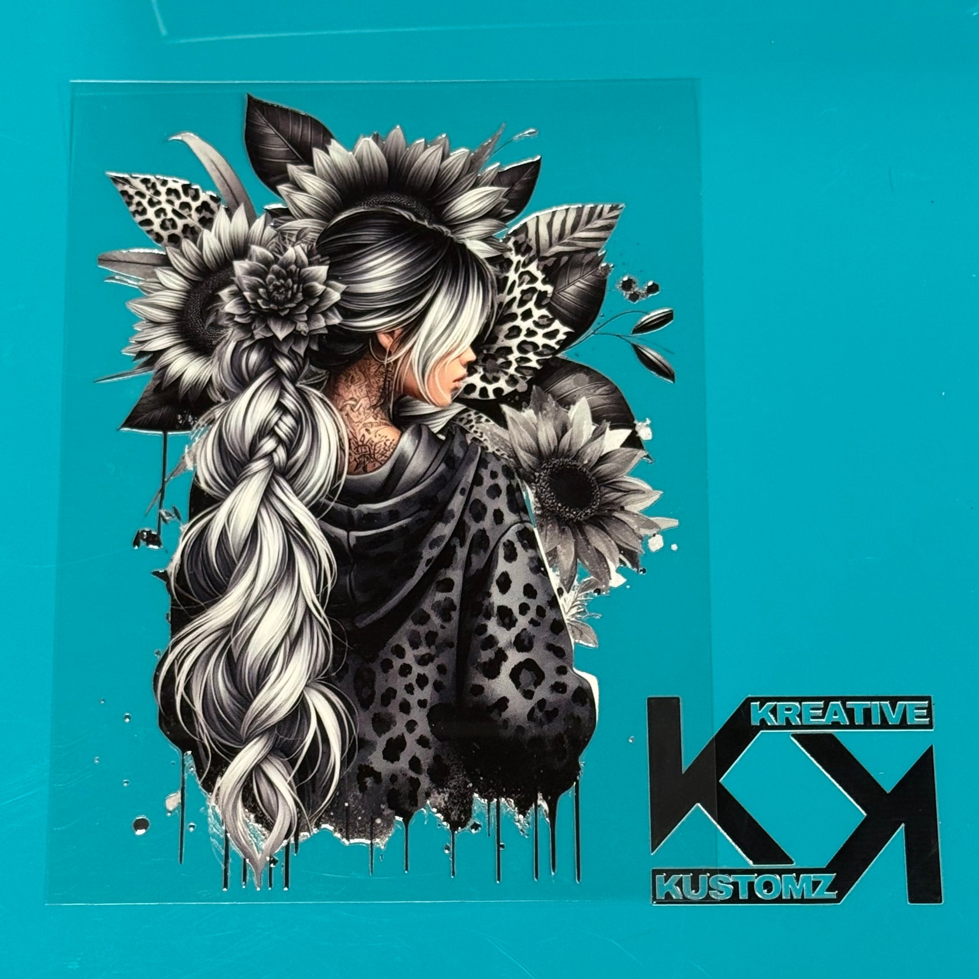 A grayscale UV-DTF decal featuring a woman with a long braid surrounded by sunflowers and leopard.