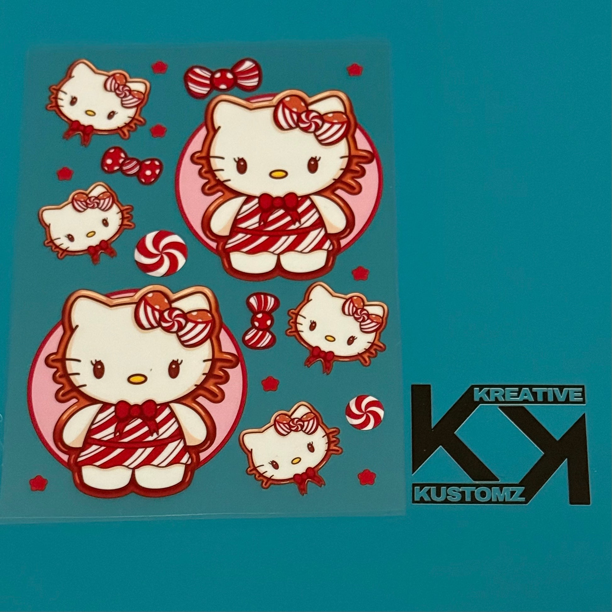 A sheet of Hello Kitty stickers featuring candy cane patterns and bows on a clear backing.