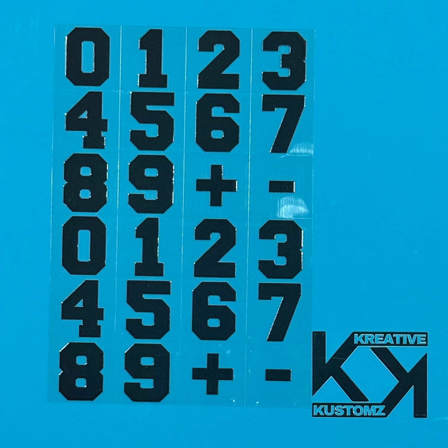 An A5 sheet of black precut adhesive numbers and symbols for UV DTF cup wraps.