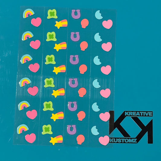 An A5 sheet of 24 precut Lucky Charms themed UV DTF decals featuring rainbows, hearts, and stars.