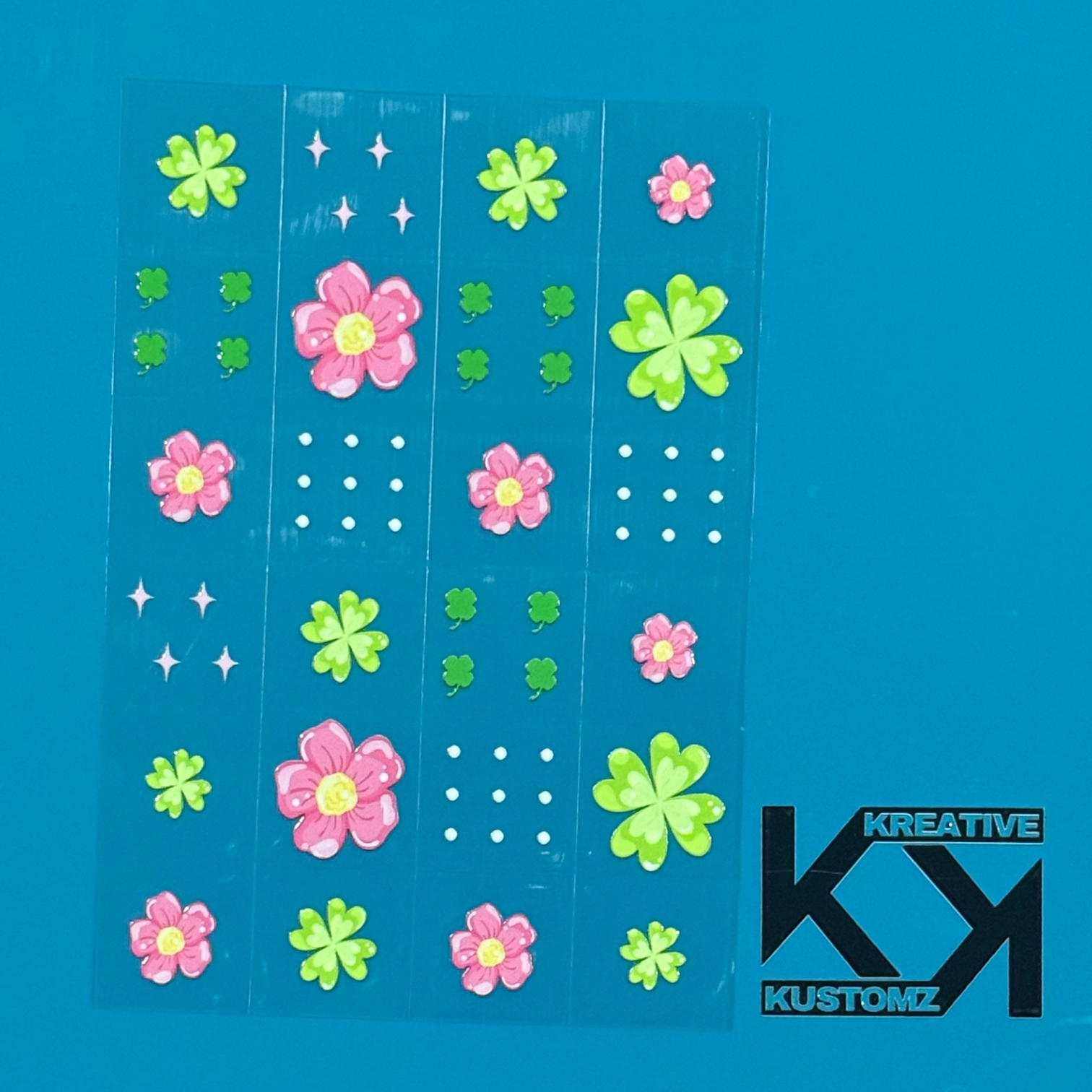 An A5 sheet of 24 floral and clover UV DTF adhesive decals on a blue background.