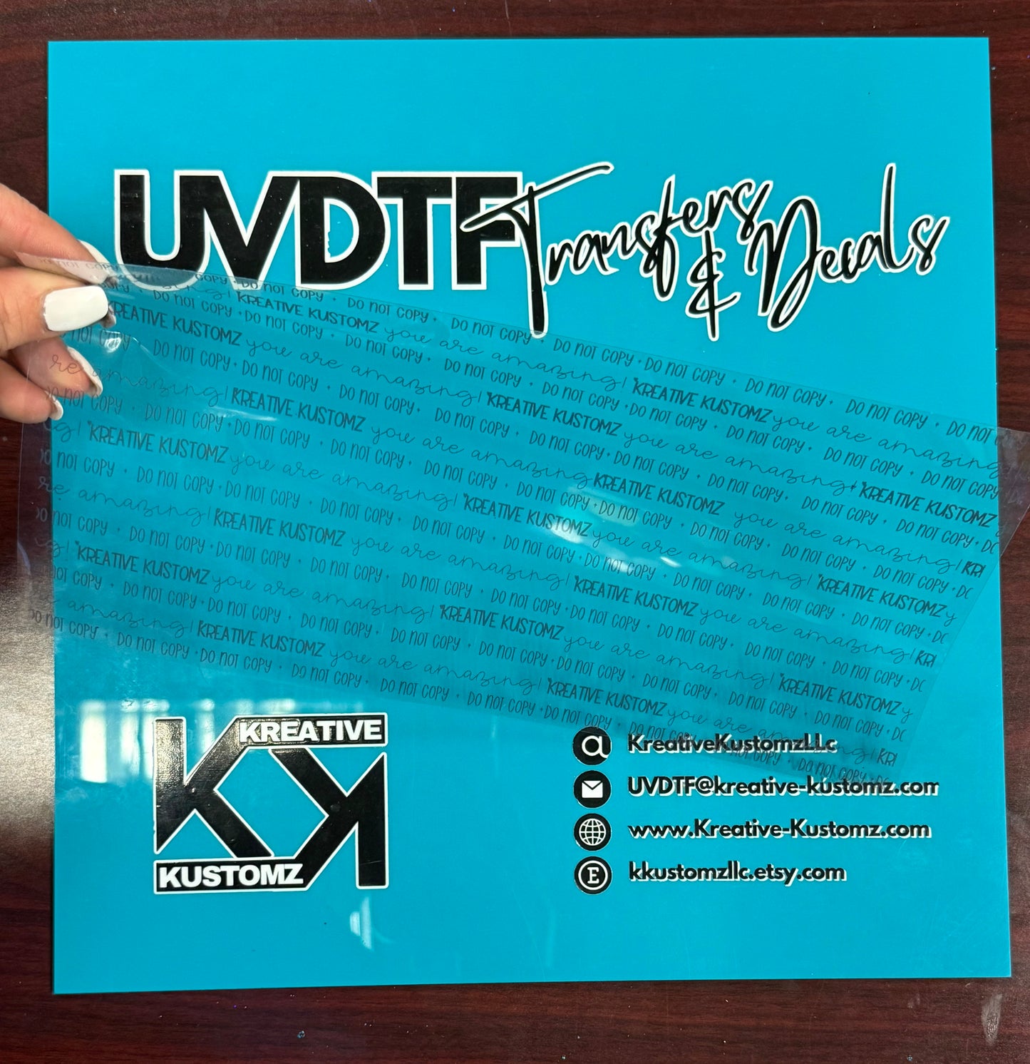 A square acrylic board with a logo and contact information printed on a bright blue background.