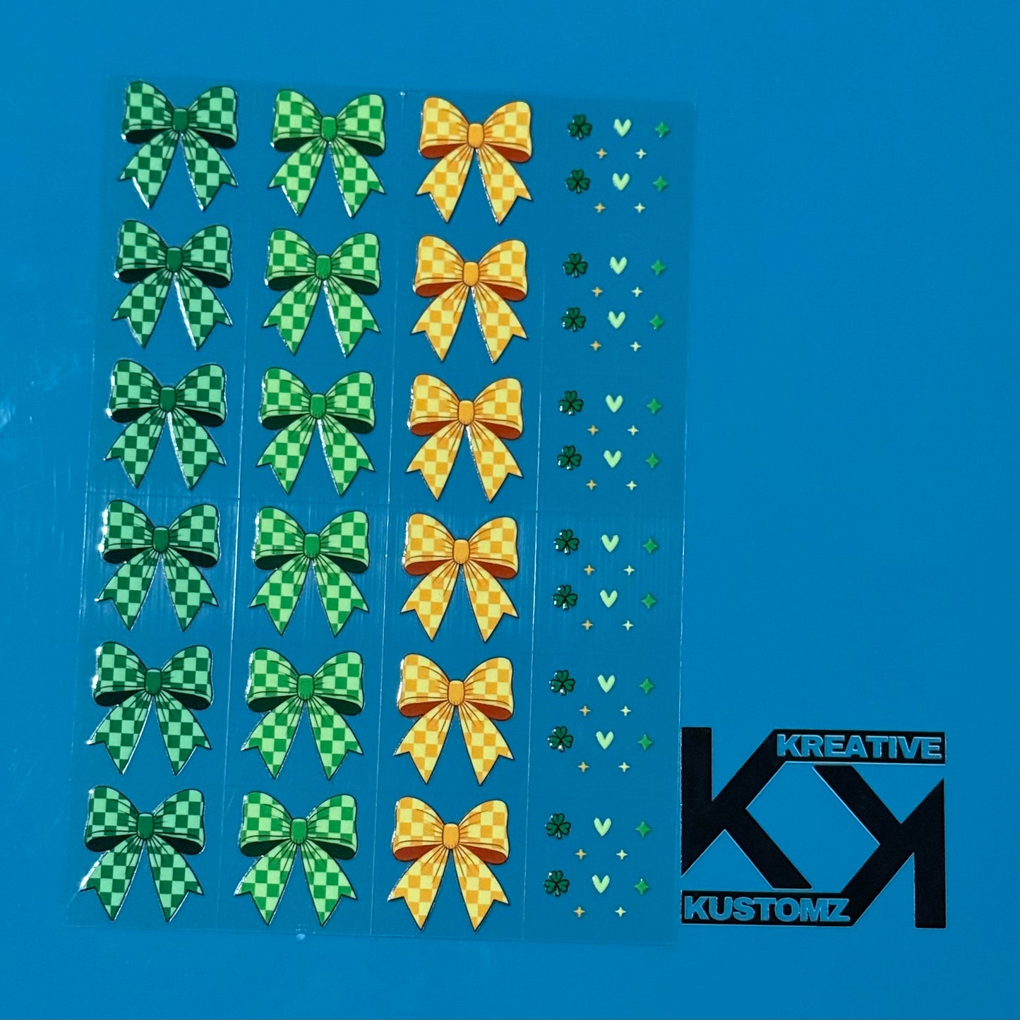 An A5 sheet of precut UV DTF decals featuring green and yellow checkered bows and small icons.