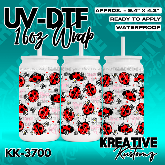 A UV DTF adhesive wrap for a 16oz glass cup featuring a pattern of ladybugs and white daisies.