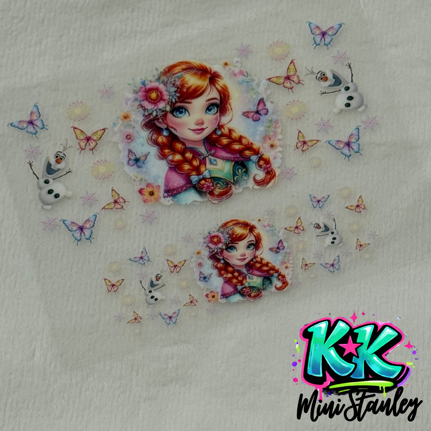 A UV DTF adhesive decal featuring Anna from Frozen, Olaf, and butterflies for a mini keychain.