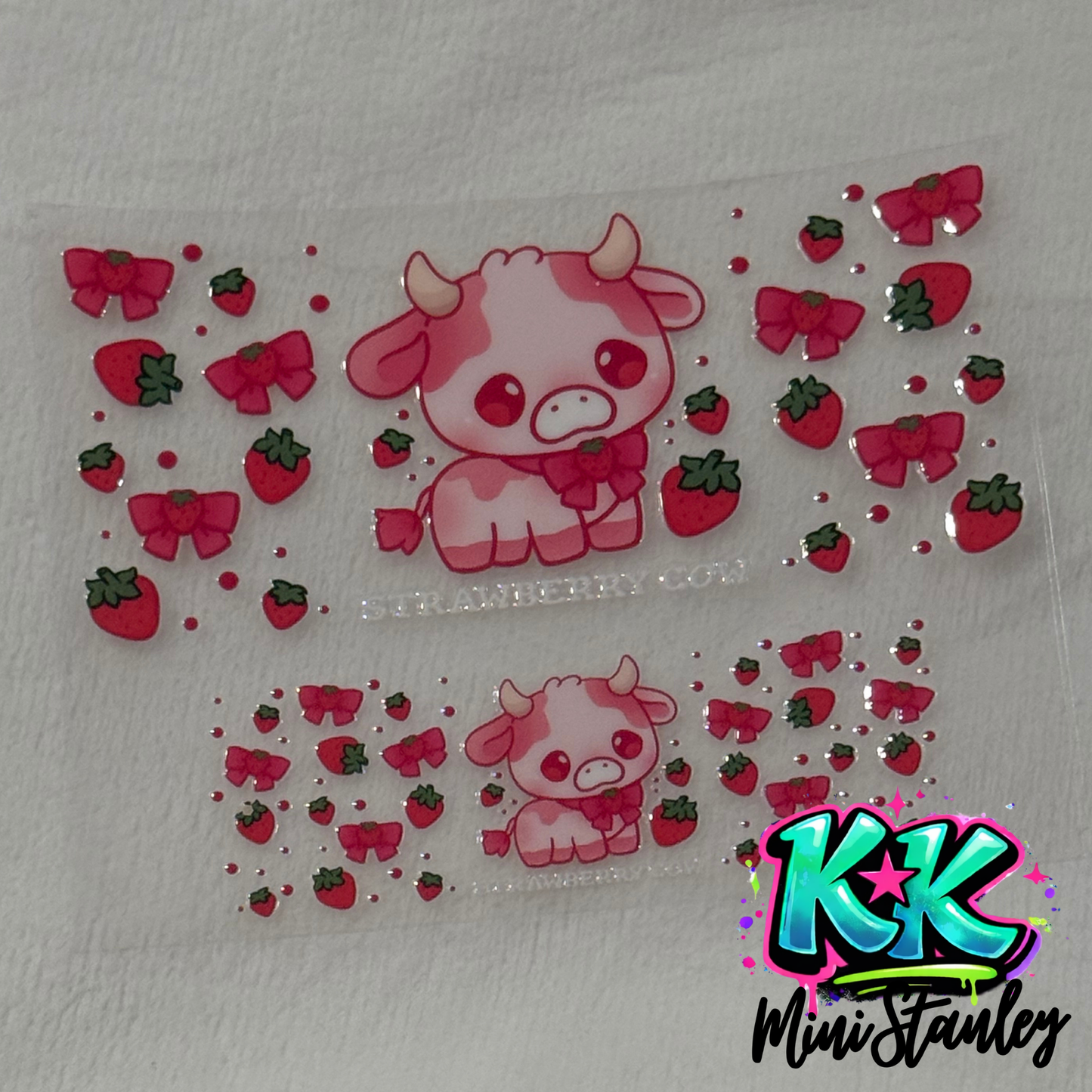 A clear UV DTF adhesive wrap featuring a pink strawberry cow, strawberries, and bows.