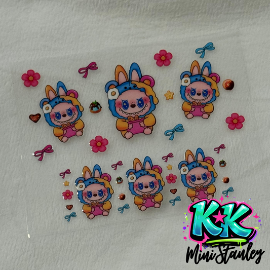 A sheet of UV DTF adhesive decals featuring cartoon bunnies in bear costumes and floral accents.