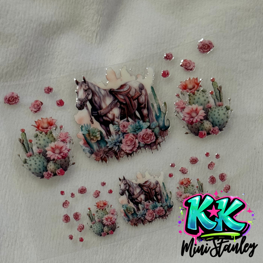 A UV DTF adhesive wrap featuring a horse, cacti, and roses for a mini keychain cup.