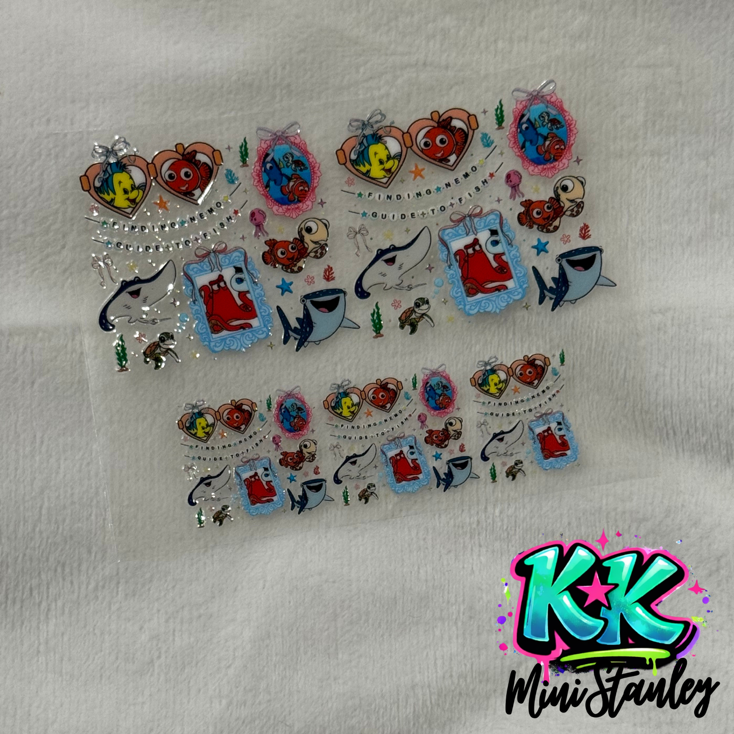 Two sheets of Finding Nemo themed UV DTF adhesive transfers for mini keychains.