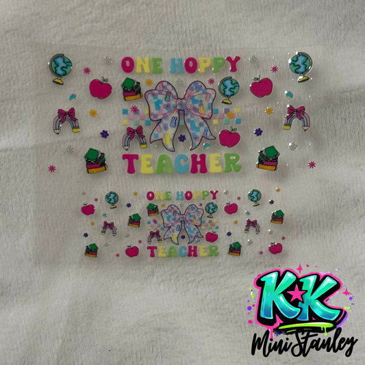 Two UV DTF adhesive transfers featuring a bow, school supplies, and One Hoppy Teacher text.