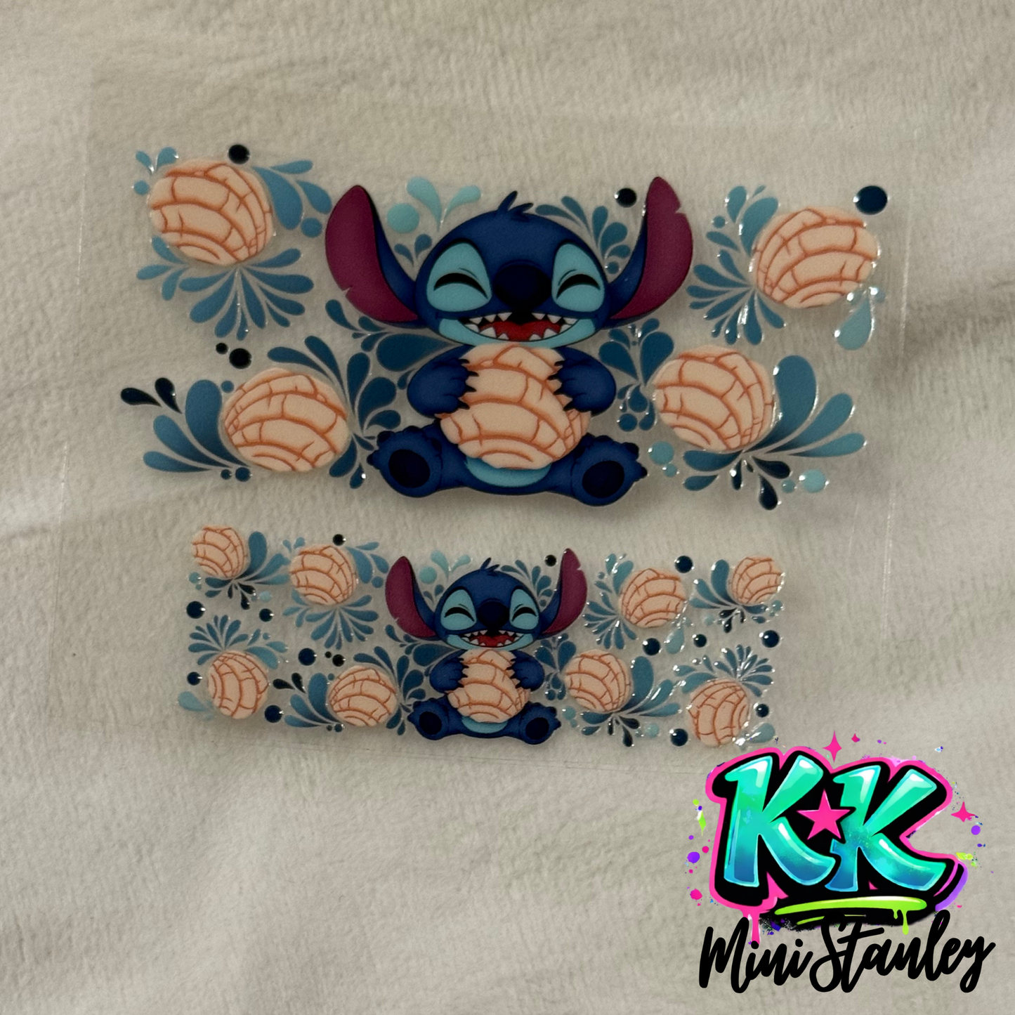 Two UV DTF adhesive transfers featuring Stitch holding a concha surrounded by blue floral accents.