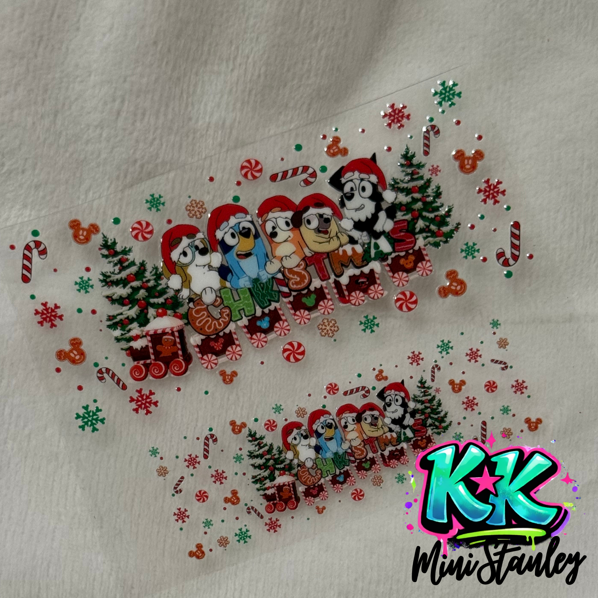 Two UV DTF adhesive decals featuring Bluey characters in Santa hats with Christmas decorations.