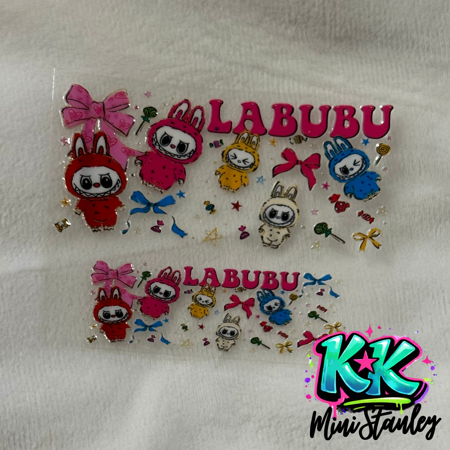 Two clear UV DTF adhesive wraps featuring Labubu characters, bows, and candy designs.