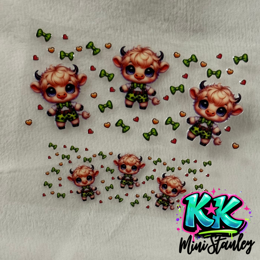 A UV DTF adhesive decal sheet featuring cartoon highland cows in green outfits with hearts and bows.