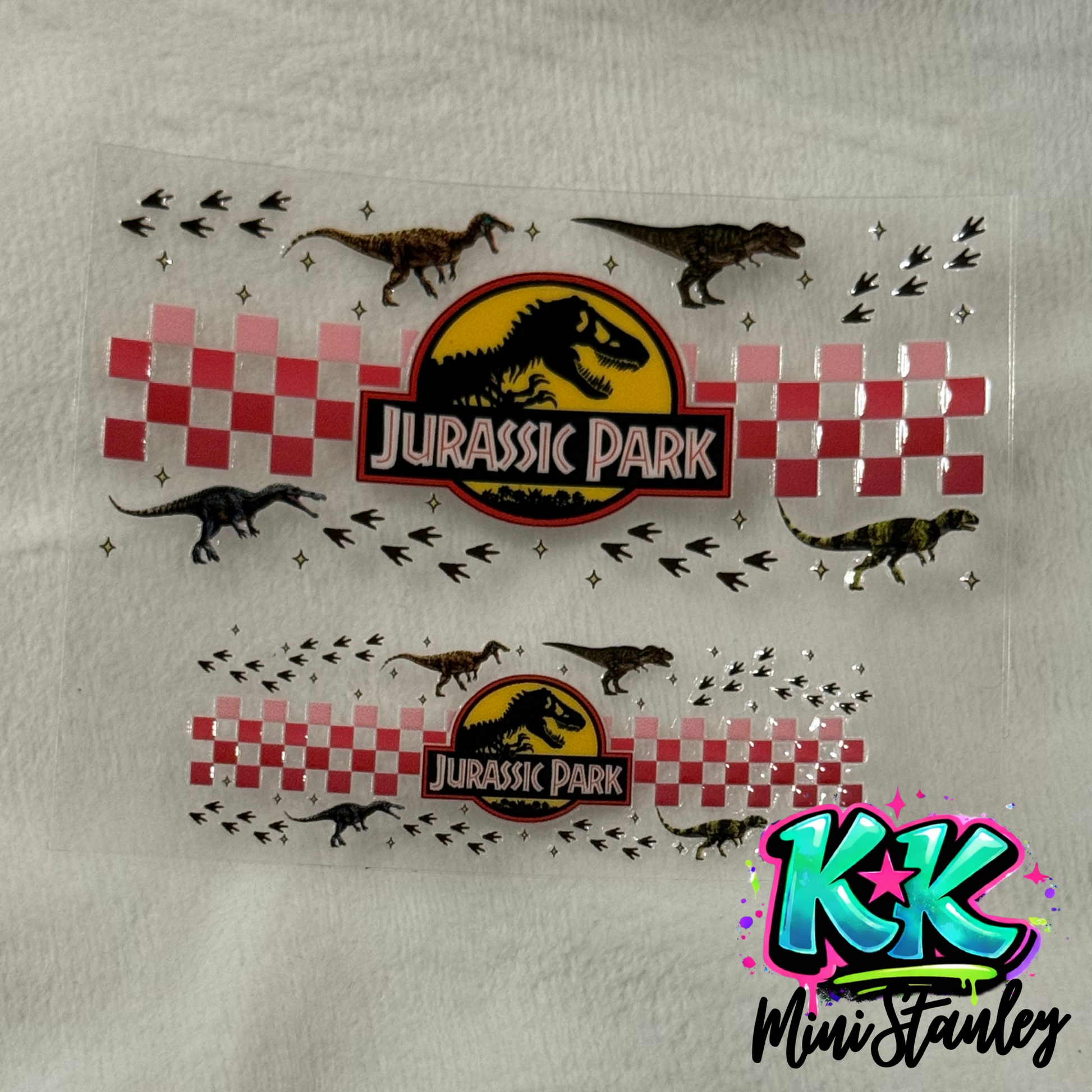 Two Jurassic Park themed UV DTF adhesive wraps for mini cups featuring dinosaurs and checkers.