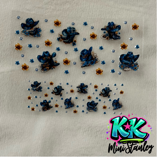 A UV DTF adhesive wrap featuring blue cowboy hats and small flowers for mini cups or keychains.