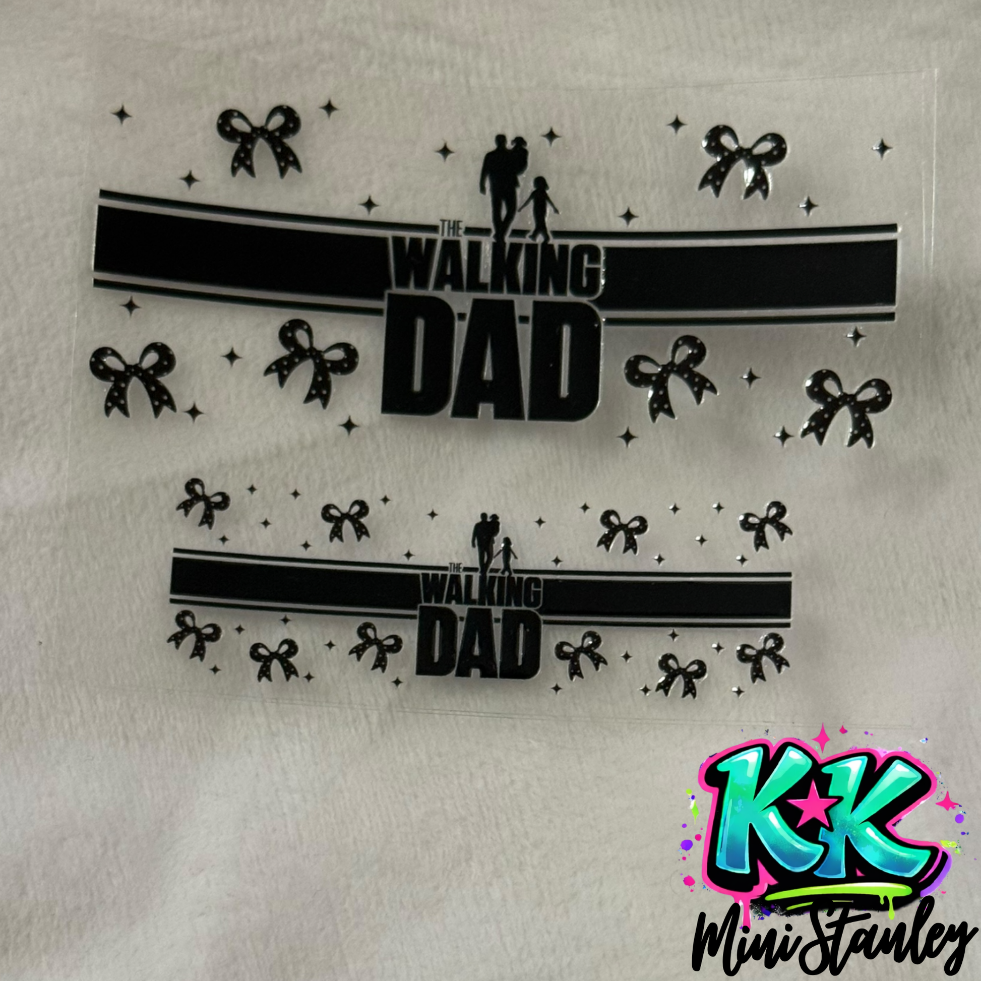 Two UV DTF adhesive wraps featuring a Walking Dad design with bows and stars on a clear sheet.
