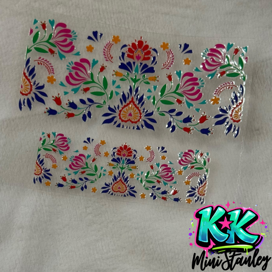 Two floral UV DTF adhesive decals with colorful folk-art patterns on a clear backing.