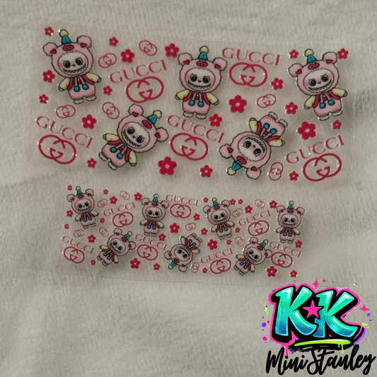 Two sheets of UV DTF adhesive decals featuring pink bear characters, flowers, and Gucci logos.