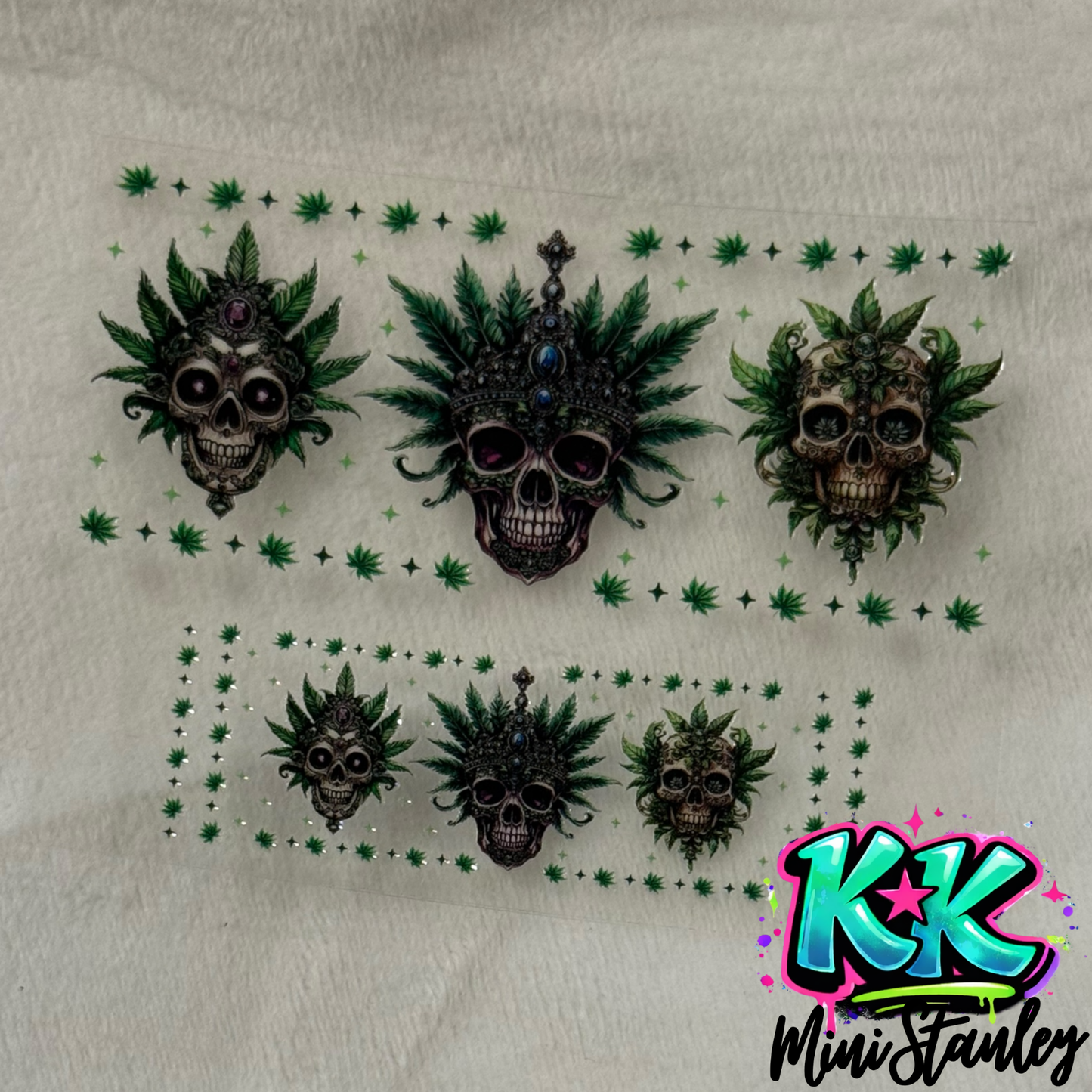 Two sheets of UV DTF adhesive wraps featuring skull and cannabis leaf designs.