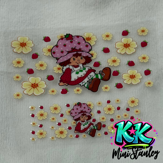 Two UV DTF adhesive decals featuring Strawberry Shortcake surrounded by yellow flowers and berries.