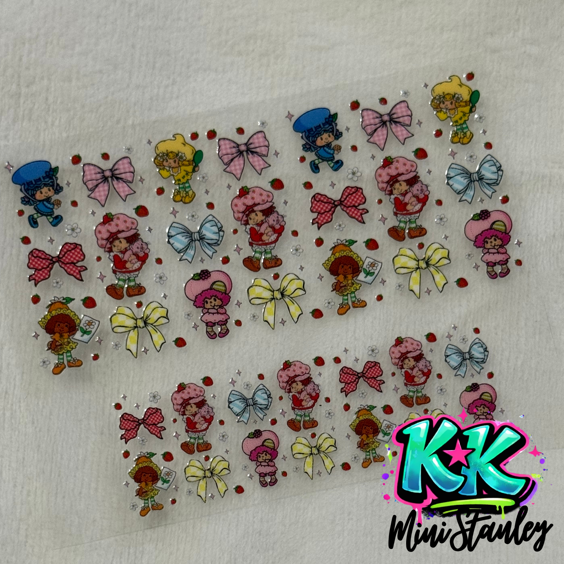 Two sheets of Strawberry Shortcake themed UV DTF adhesive transfers for mini keychains.