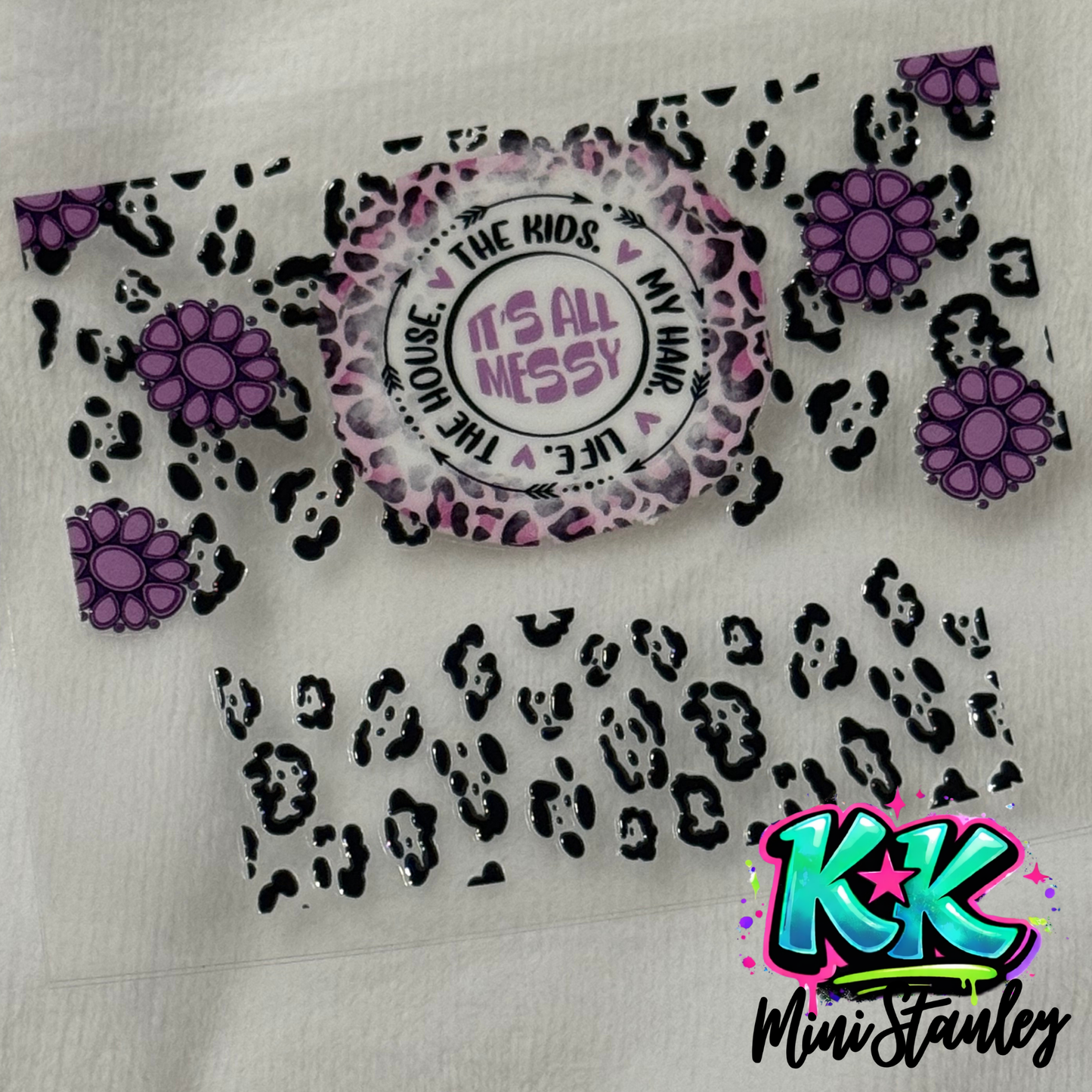 A UV DTF adhesive wrap for a mini keychain featuring a leopard print, purple flowers, and text.