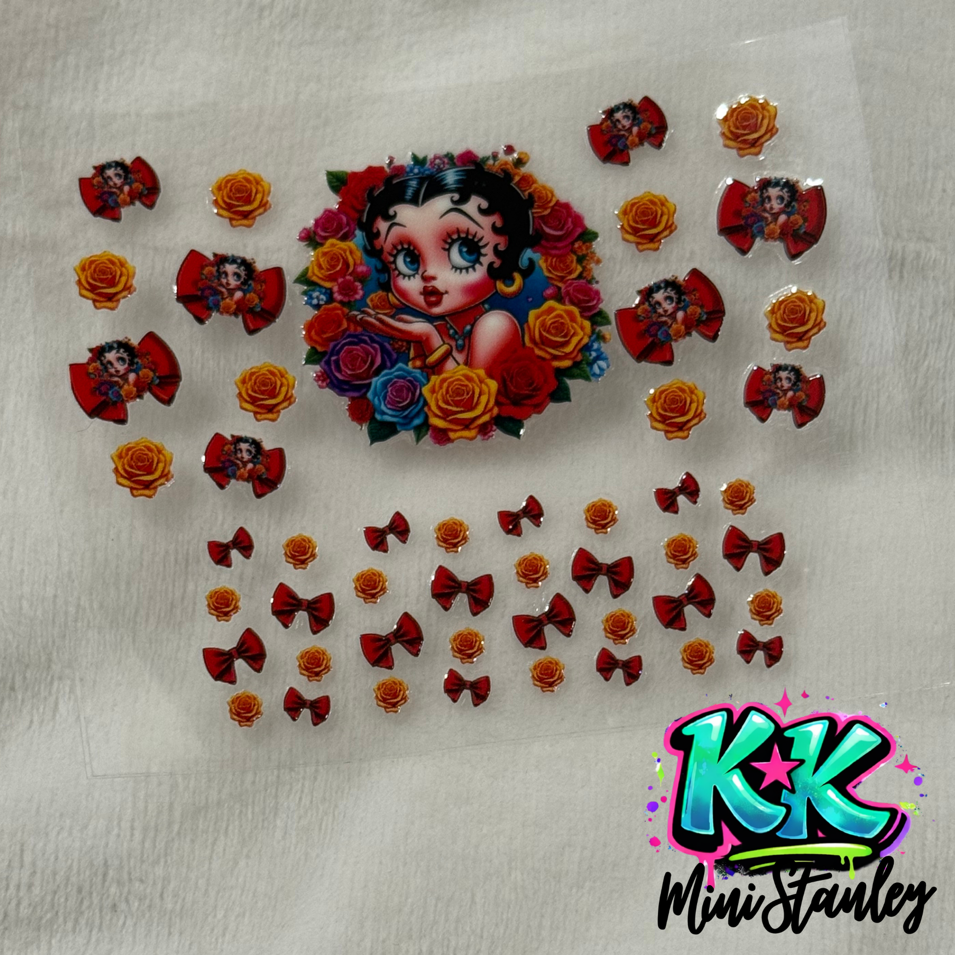 A sheet of UV DTF decals featuring Betty Boop, red bows, and yellow roses for mini cups.
