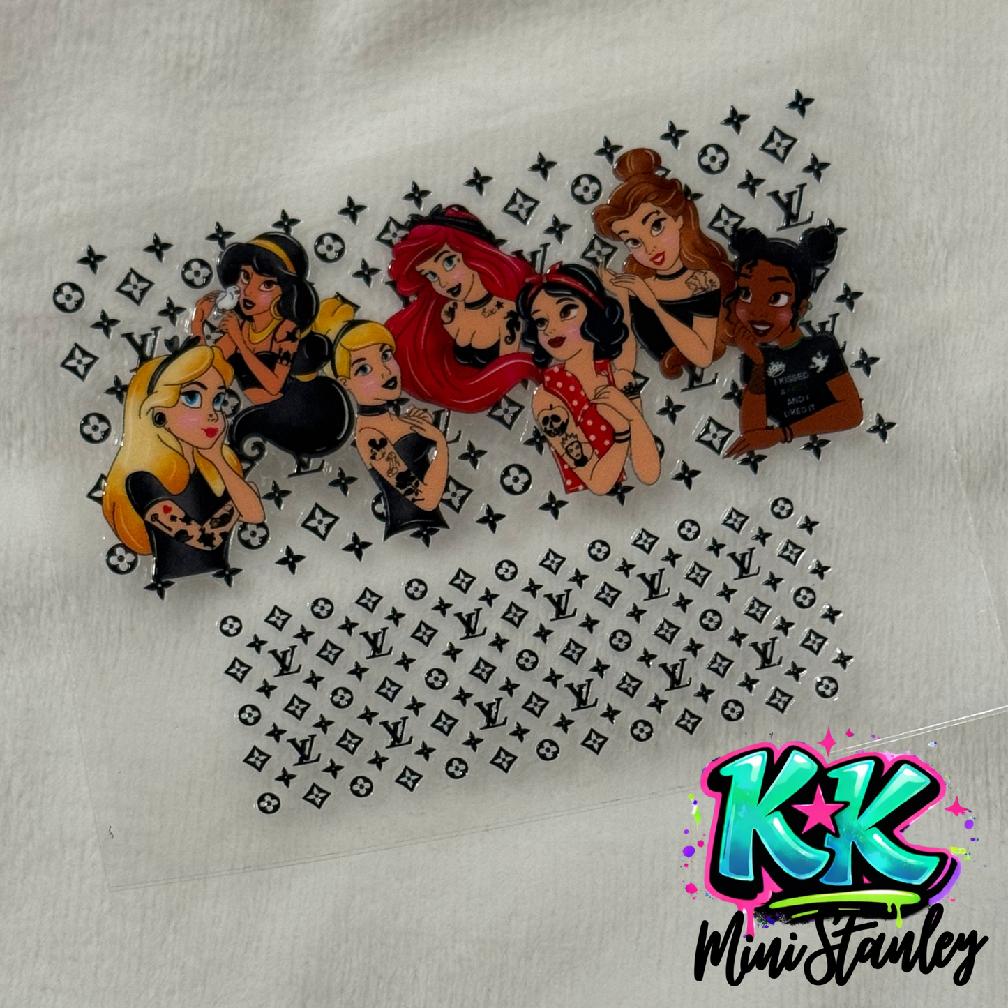 A UV DTF adhesive wrap featuring tattooed Disney princesses against a Louis Vuitton logo pattern.