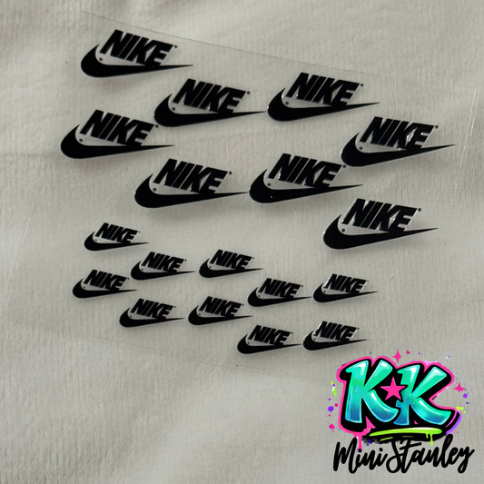 A sheet of black Nike logo UV DTF adhesive decals for mini keychains.