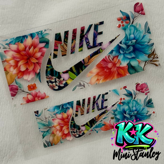 Two floral patterned Nike logo UV DTF adhesive transfers for mini keychains on a white background.