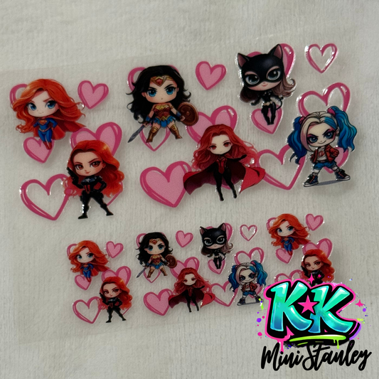 A UV DTF transfer sheet featuring chibi-style female superheroes and pink hearts.