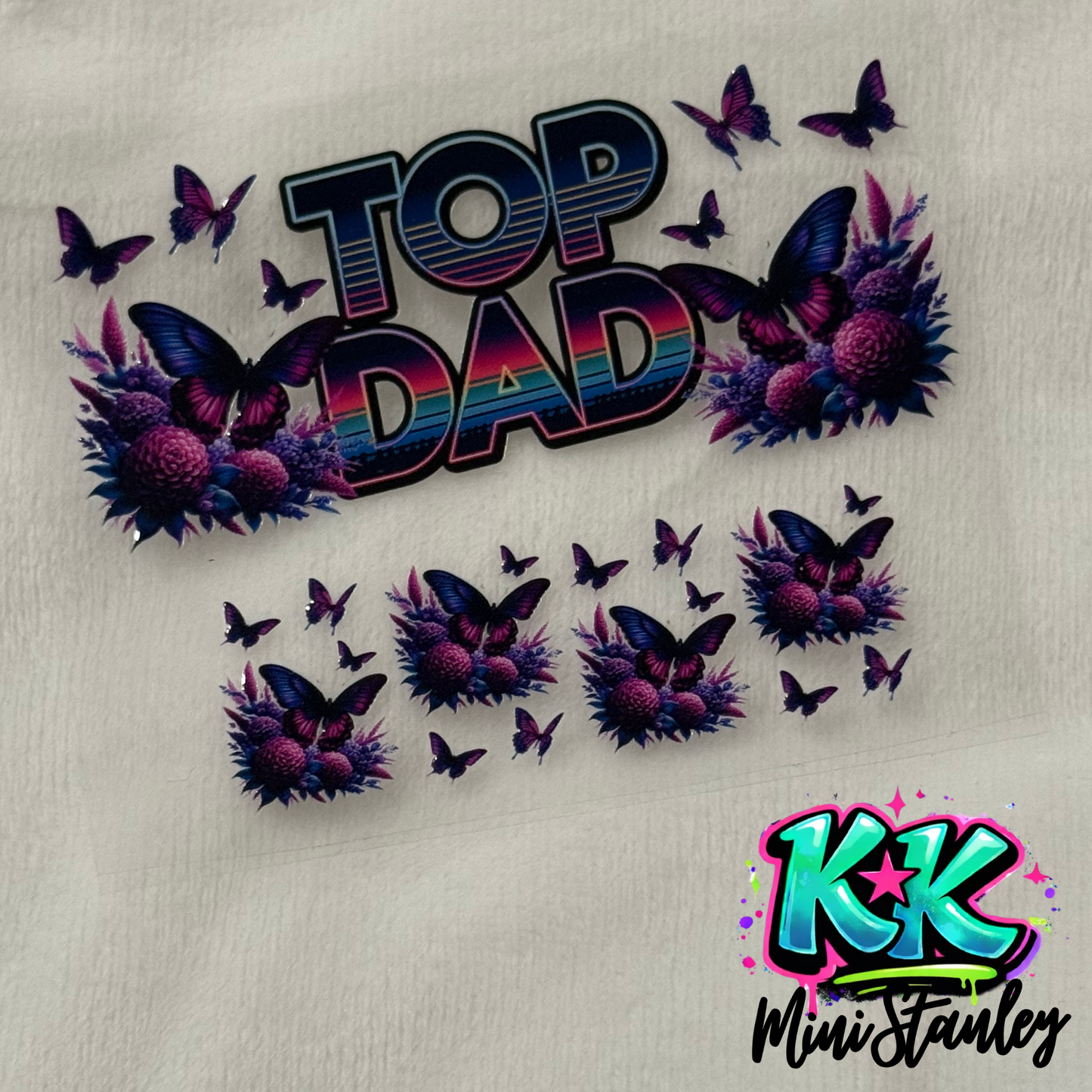A UV DTF adhesive wrap featuring a Top Dad text design with purple butterflies and floral accents.